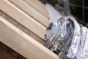 Houtskeletbouw met isolatie en reflecterende folie voor duurzame constructie.