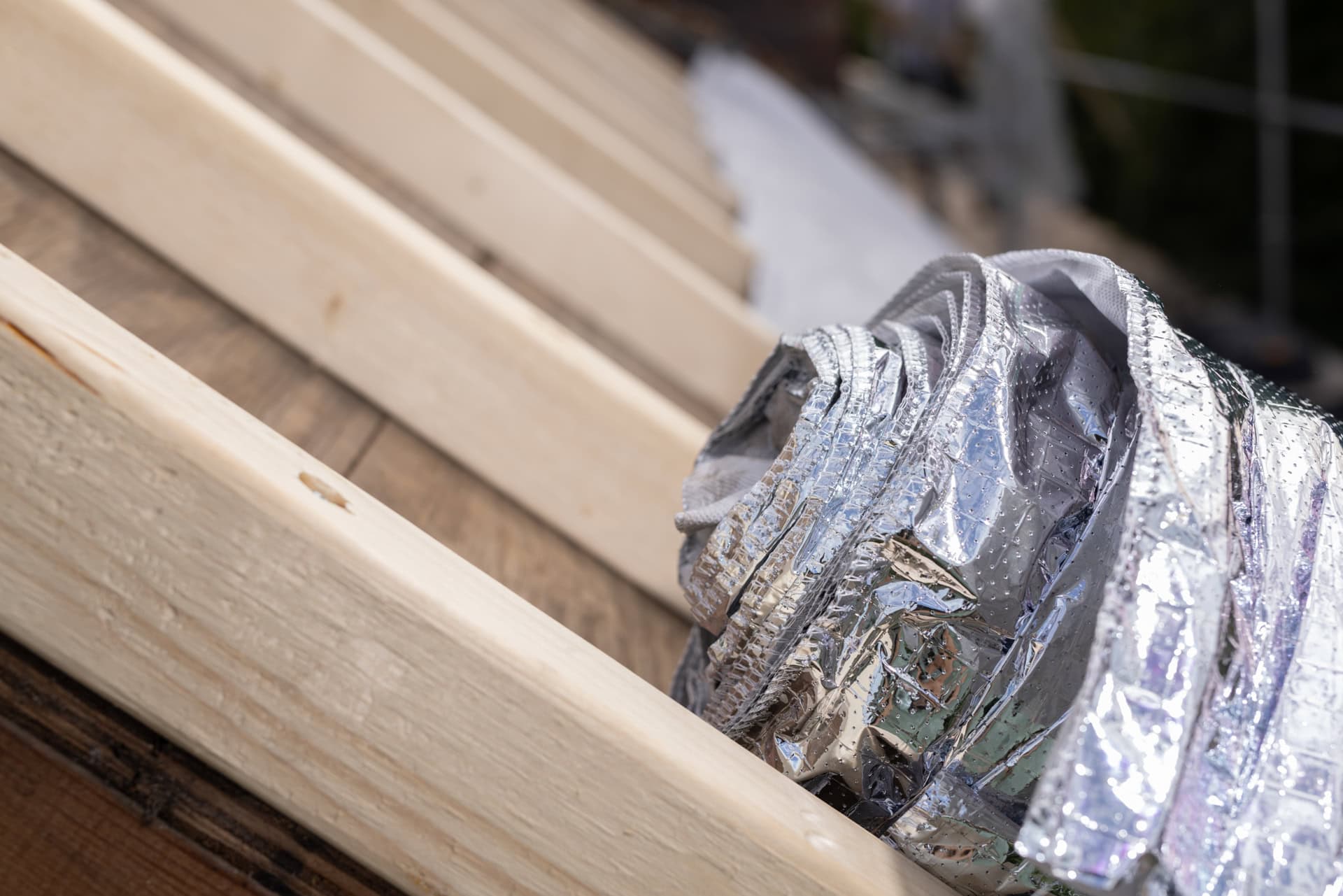 Houtskeletbouw met isolatie en reflecterende folie voor duurzame constructie.