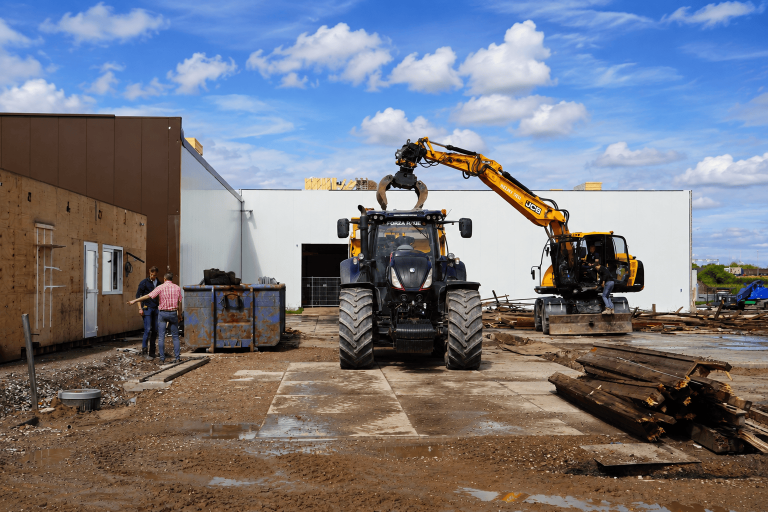Bouwplaats met graafmachine en bouwvakkers voor nieuw bedrijfspand.