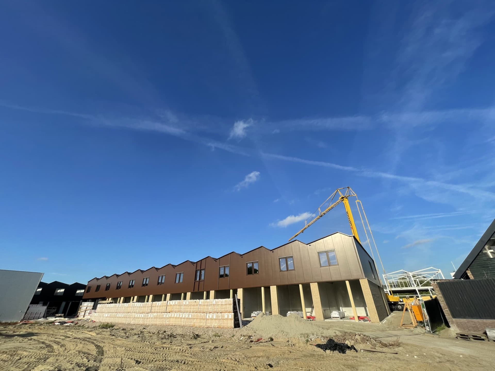 Nieuwbouw van Pijlers met bouwkraan en open bouwplaats.